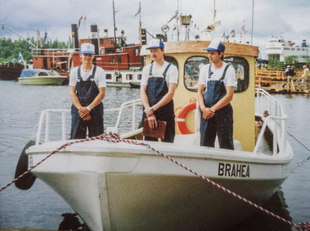 Kuvassa vapaaehtoisia järvipelastajia pelastusalus Brahean kannella sen vihkimisitilaisuudessa heinäkuussa 1986. Taustalla höyrylaivaregattaan osallistuneita aluksia.